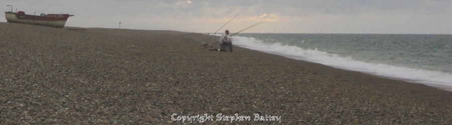 Lone fisherman on shingle beach
